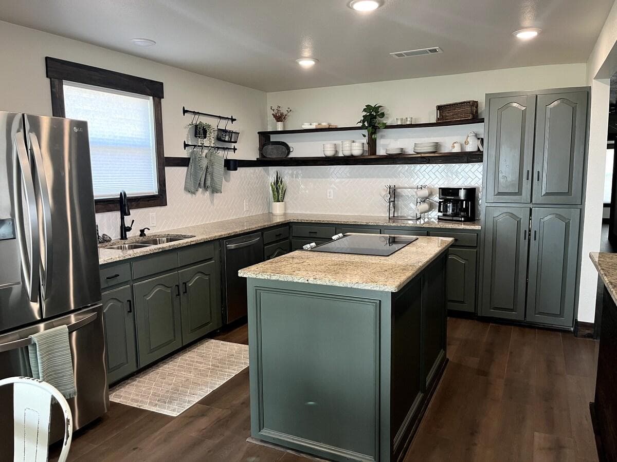 Fully stocked kitchen with island cooktop and bar seating. Cookware, dishes and full size appliances.